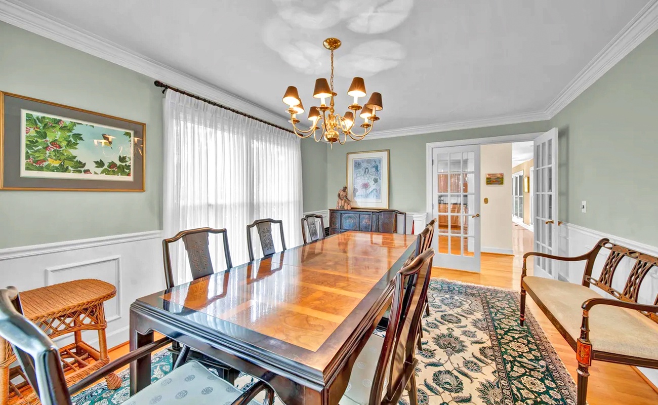 Gather around this elegant dining table where memorable meals and conversations unfold beneath the warm chandelier glow.