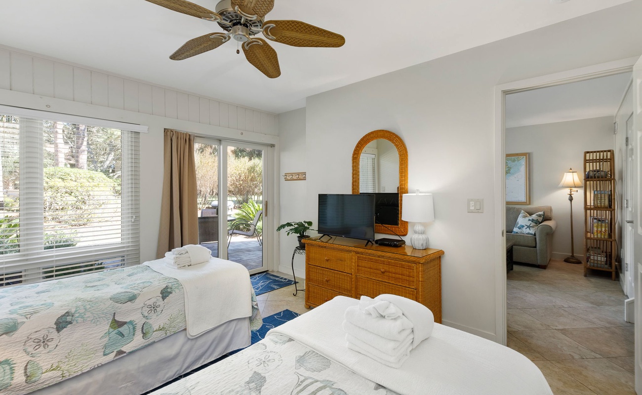 Relax in your bright bedroom with tropical ceiling fan, garden views, and cozy twin beds perfect for peaceful sleep.