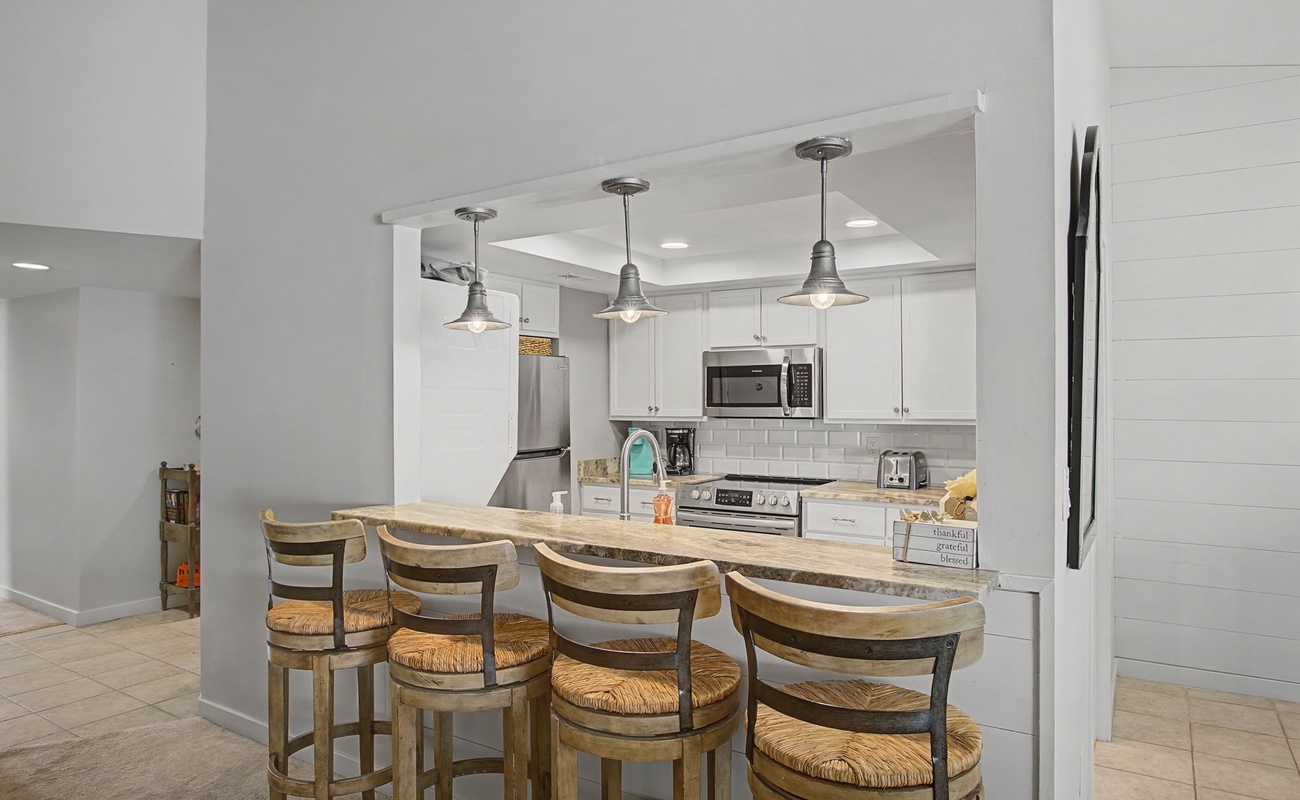 Your fully equipped kitchen features a breakfast bar where you can enjoy morning coffee while planning your day's adventures.