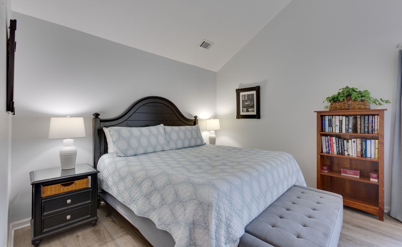 Your peaceful bedroom retreat features a plush bed with soft linens and a cozy reading nook with books nearby.
