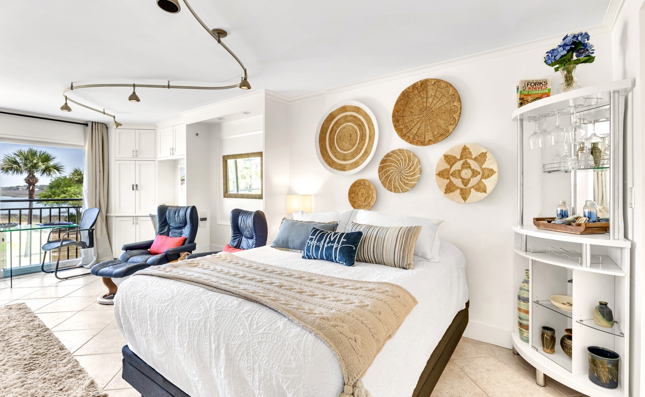 Drift off to sleep in your coastal haven with handwoven basket art above the plush bed and poolside balcony doors that invite morning breezes.