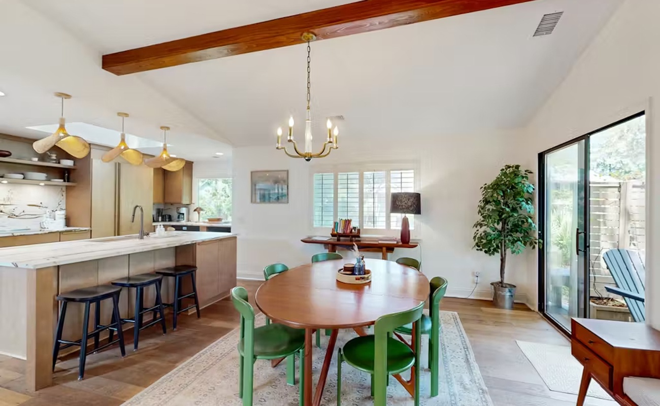 Gather around this stunning dining space where warm wood beams frame your meals and natural light floods through expansive windows.