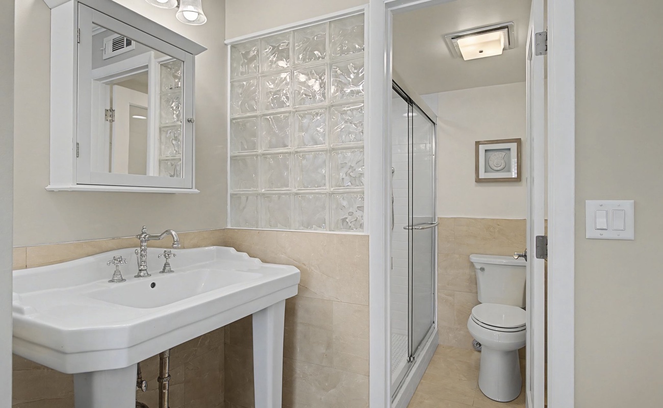 Step into your elegant ensuite bathroom with stylish pedestal sink, spacious glass shower, and tasteful finishes throughout.
