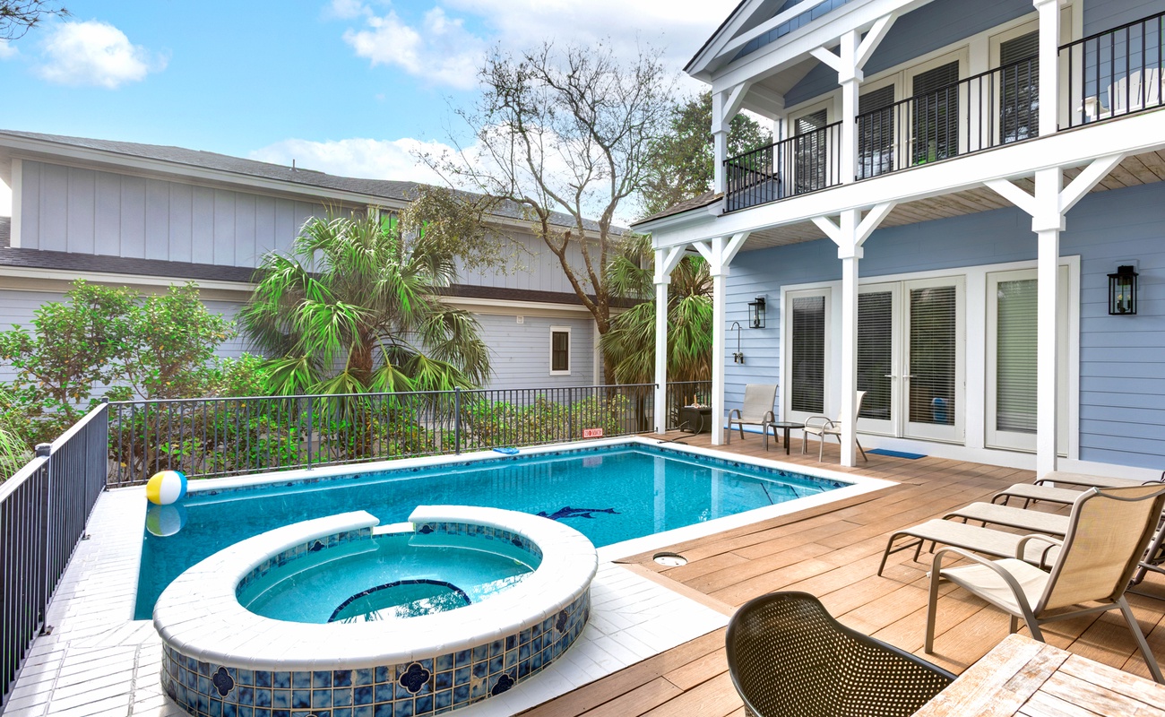 Your private oasis awaits with a sparkling pool and relaxing hot tub surrounded by comfortable loungers and tropical greenery.