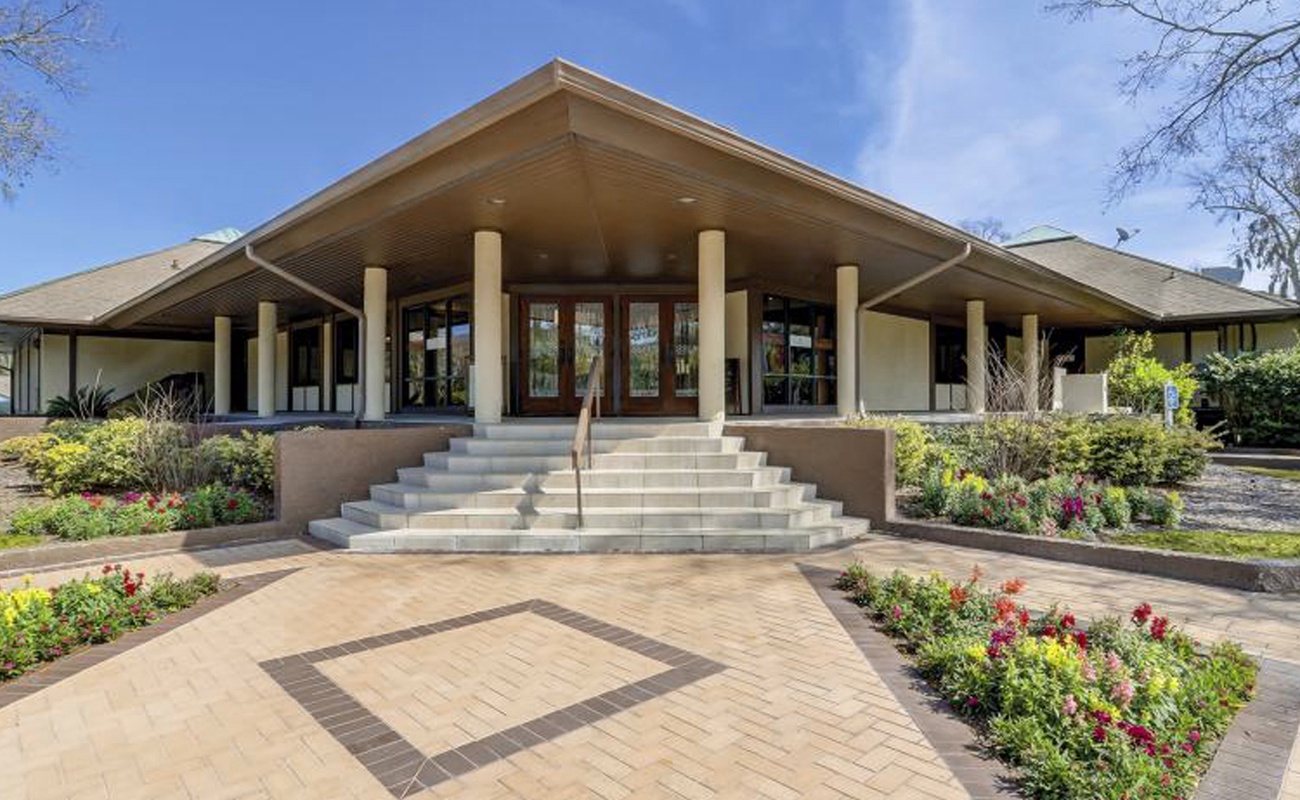 Elegant entrance with grand steps and beautifully landscaped gardens welcomes visitors to this distinctive property.