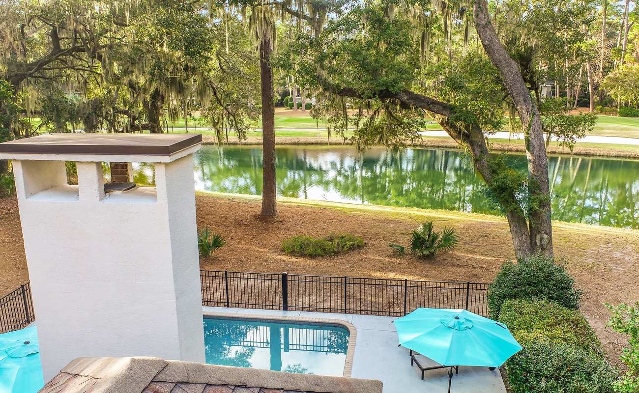 Stunning lagoon views and private pool create your perfect outdoor paradise beneath majestic oak trees.