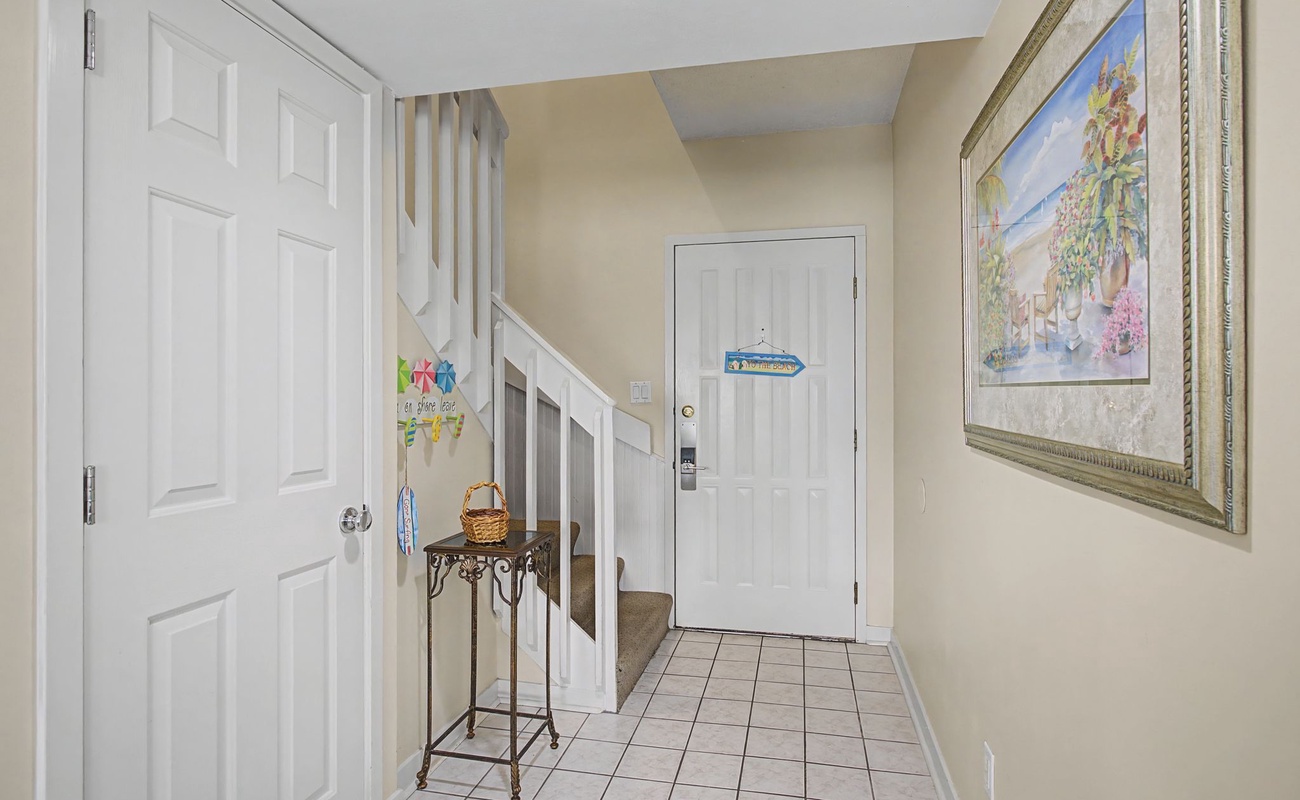 Step inside your welcoming entryway, where coastal artwork and thoughtful touches create an instantly relaxing atmosphere for your beach getaway.