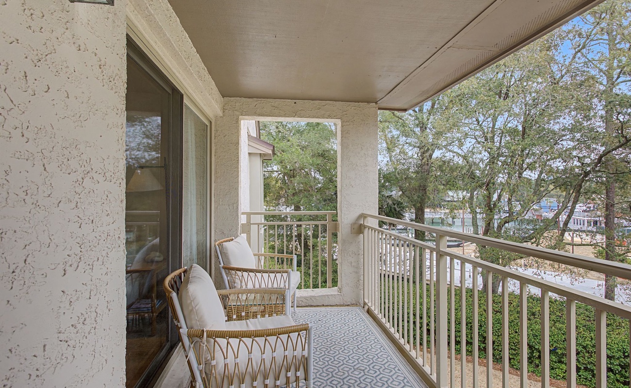 Unwind on your private covered balcony with comfortable wicker seating overlooking leafy neighborhood views.