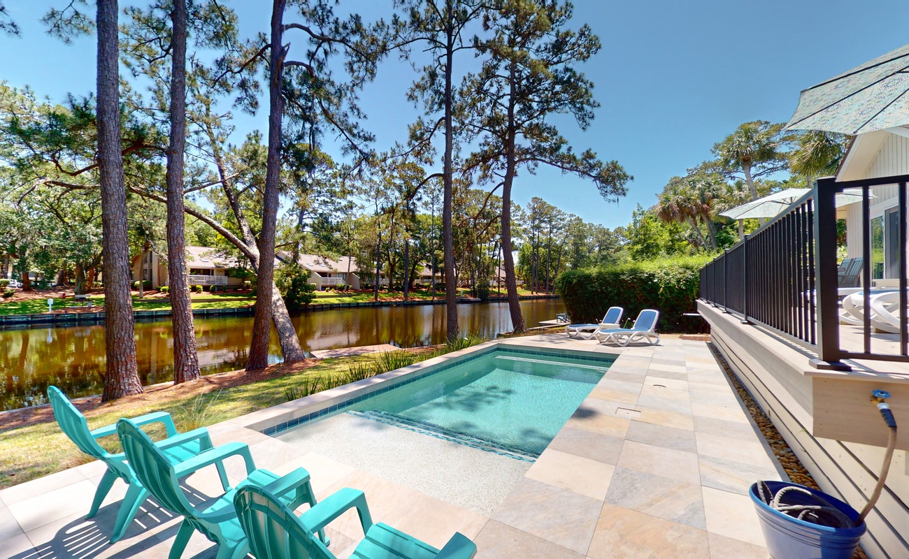 Private pool oasis surrounded by towering pines and peaceful lagoon views for your perfect retreat.