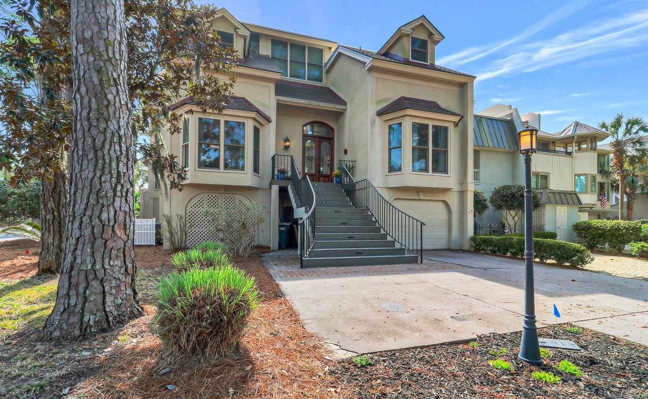 Beautiful coastal property with elegant architectural details and welcoming entrance stairs in a peaceful neighborhood setting.