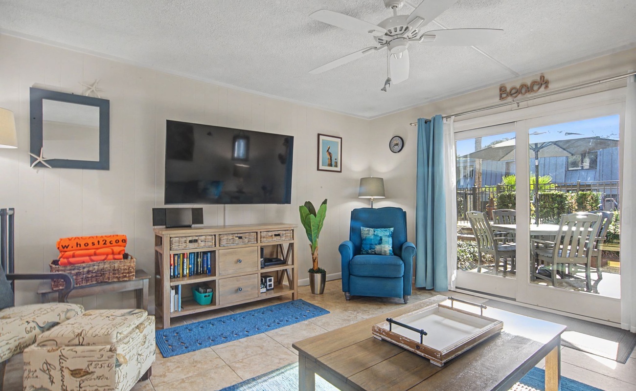 Relax in your bright living space with ocean-themed decor, comfy seating, and sliding doors to your outdoor oasis.