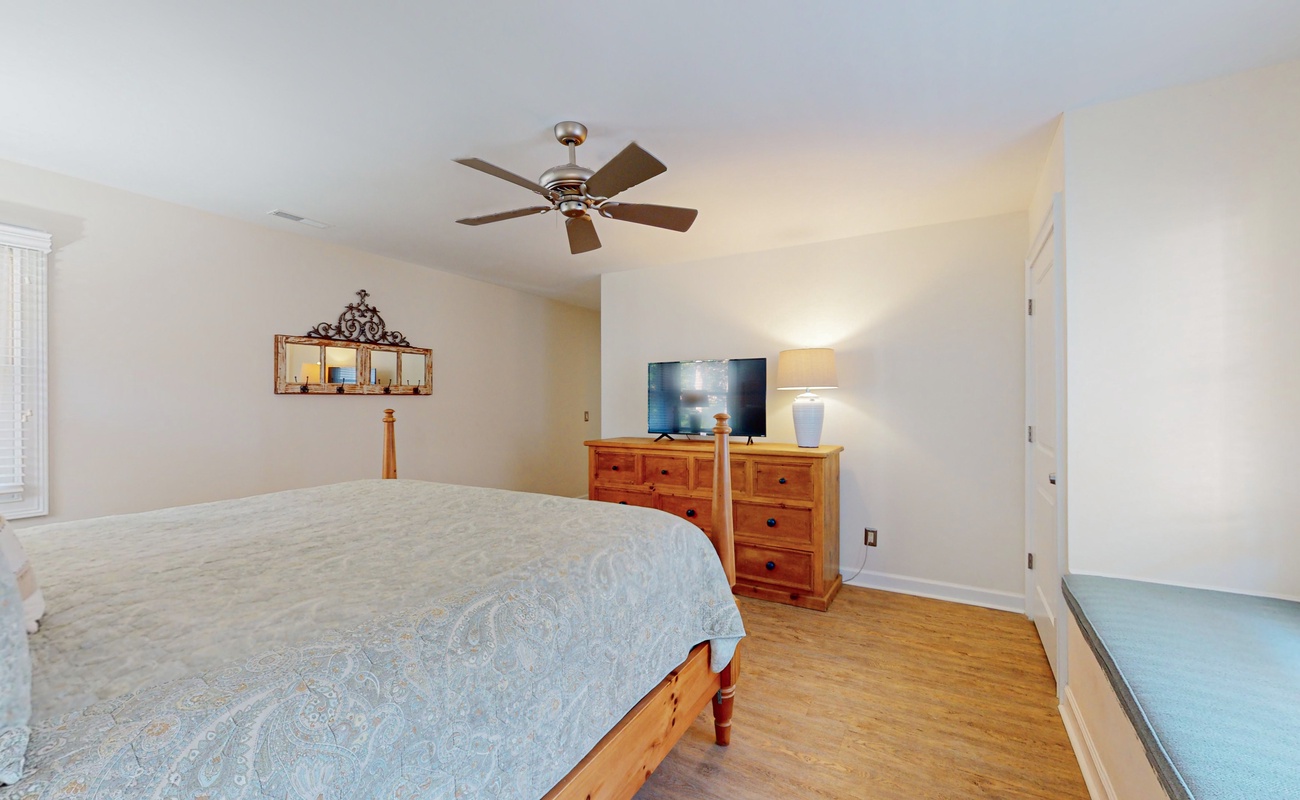 Unwind in your peaceful bedroom with cozy furnishings, ceiling fan, and entertainment center for relaxing evenings.