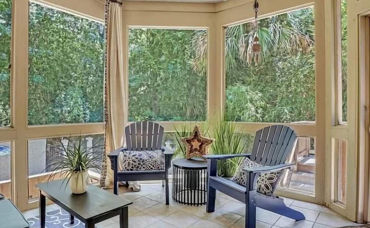 Relax in your private screened porch surrounded by lush tropical greenery, complete with comfortable seating and peaceful garden views.