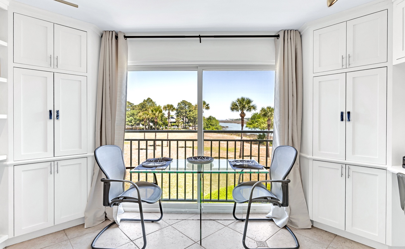 Your bright dining space opens to a serene water view, where morning coffee tastes better with palm trees swaying outside your window.