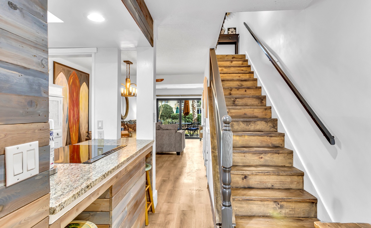 Step into your welcoming entryway where rustic wood beams meet modern elegance, leading you upstairs to comfort.