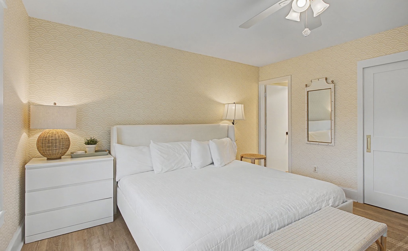 Sink into crisp white linens in your serene bedroom, where textured walls and natural wood accents create the perfect retreat for peaceful nights.