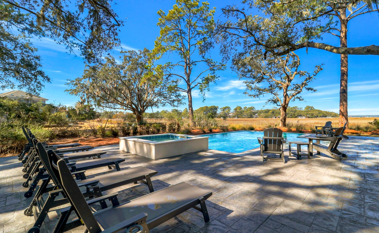 Dive into your private oasis surrounded by majestic trees and natural beauty, where sun-warmed loungers await your perfect poolside retreat.