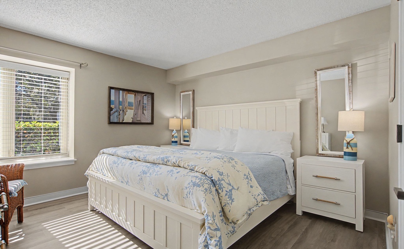 Sink into the comfortable king bed with soft linens in your bright, serene bedroom featuring modern coastal decor and peaceful natural light.
