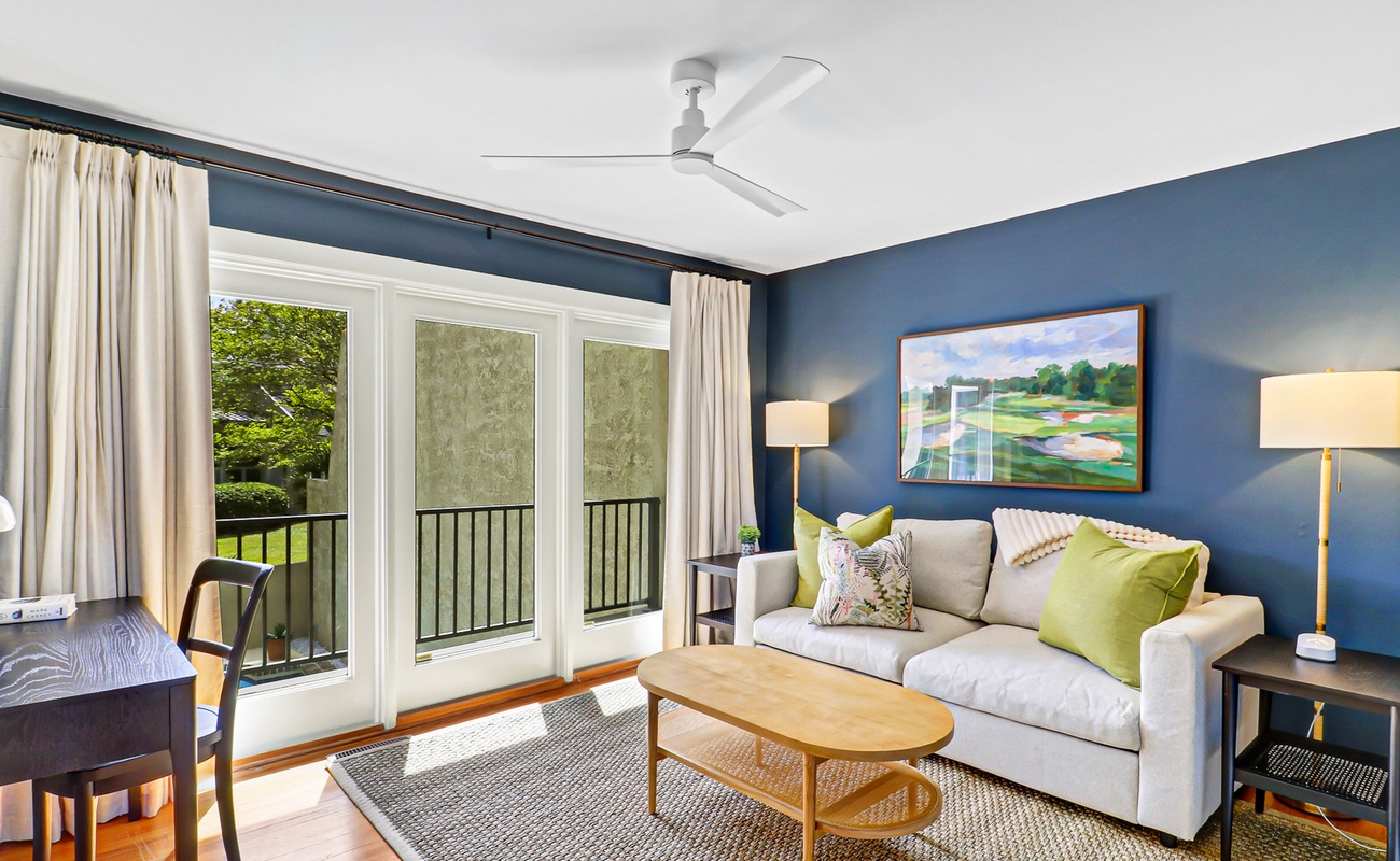 Unwind in your stylish living room with plush seating, natural light streaming through French doors, and a peaceful balcony view.