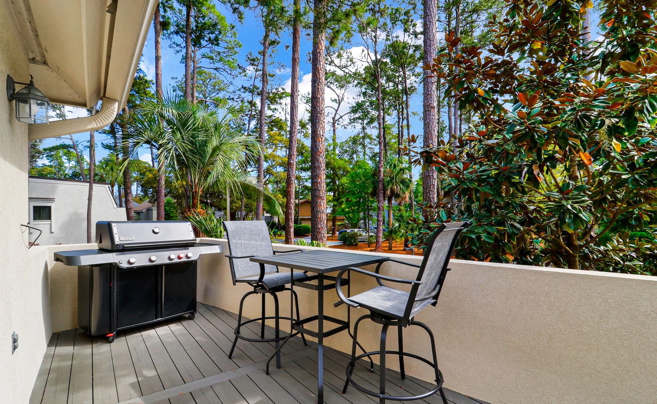 Fire up the grill on your private patio surrounded by tropical palms and towering pines—your perfect outdoor dining escape awaits.