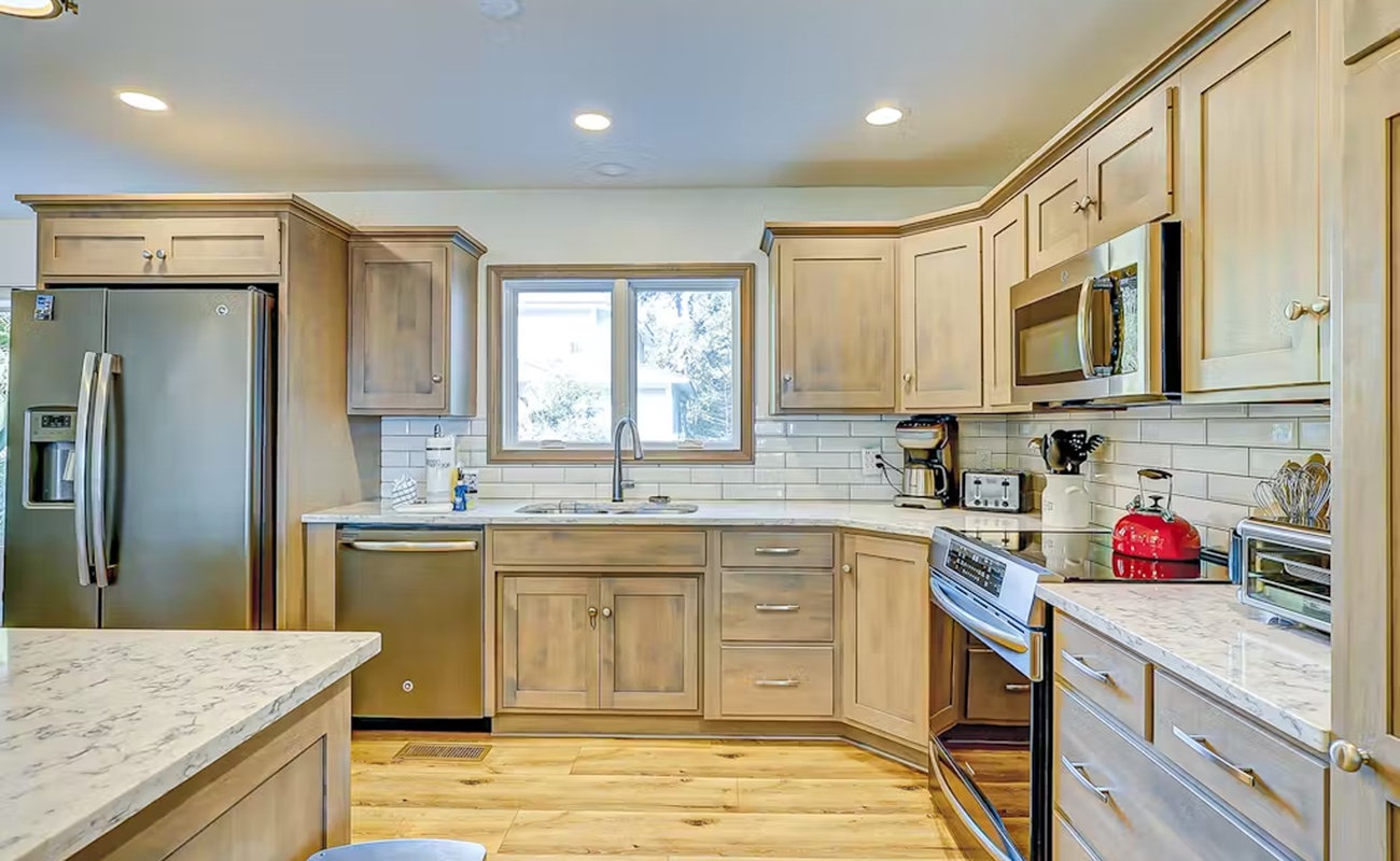 Your spacious kitchen features marble countertops, stainless steel appliances, and warm wood cabinetry—perfect for preparing meals together during your stay.