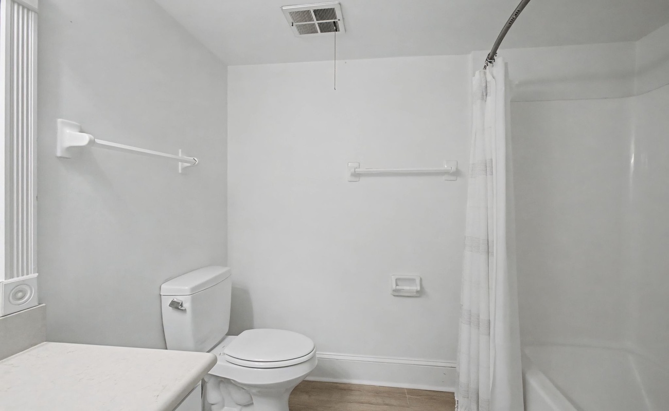 Your spotless bathroom features a spacious tub-shower combo with accessibility rails for comfort and safety.