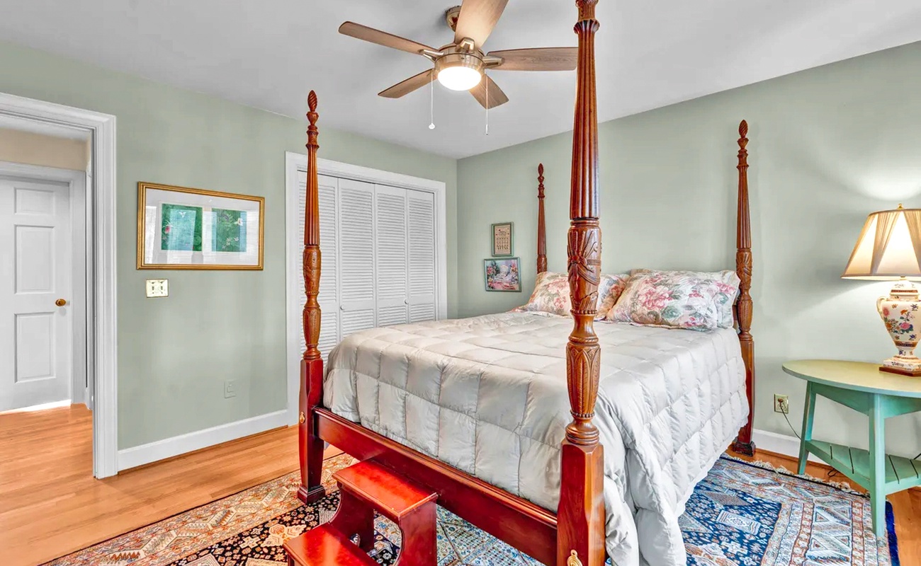 Step into your elegant bedroom sanctuary with a stunning four-poster bed, gentle ceiling fan, and charming vintage touches that create perfect comfort.