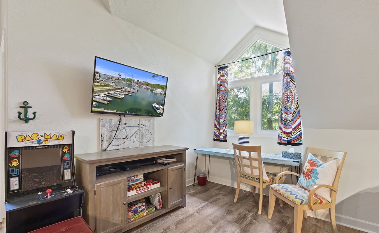Your cozy retreat features a vintage arcade game, modern TV, and bright dining nook where memories are made.
