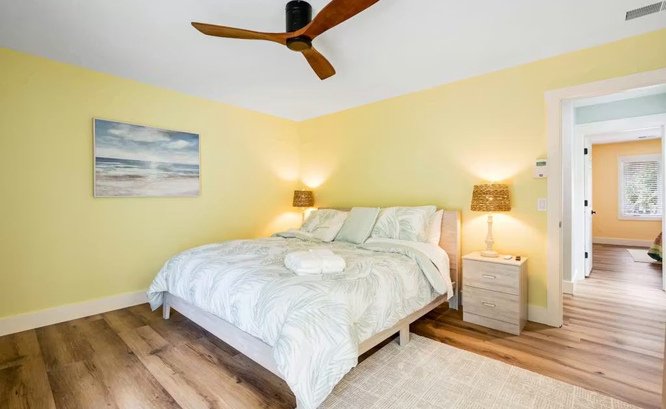 Drift off in your sunny bedroom with coastal vibes, soft linens, and warm wood floors keeping you comfortable.