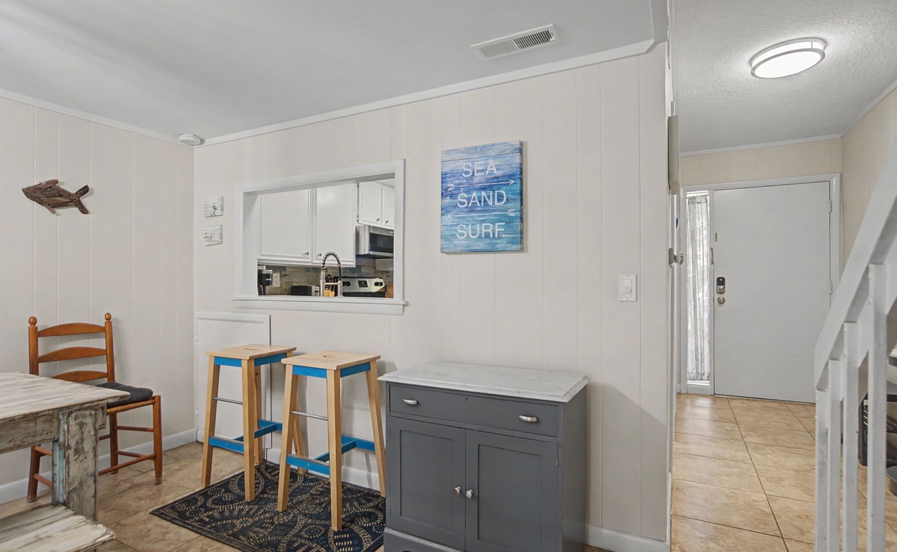 Your coastal dining nook features charming beachy decor and convenient kitchen window service for easy meal prep and entertaining.