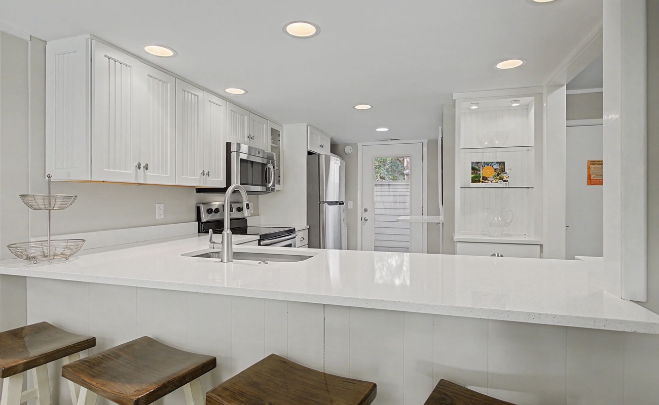 Your bright, open kitchen features gleaming countertops and modern appliances, perfect for whipping up morning coffee or preparing meals together.