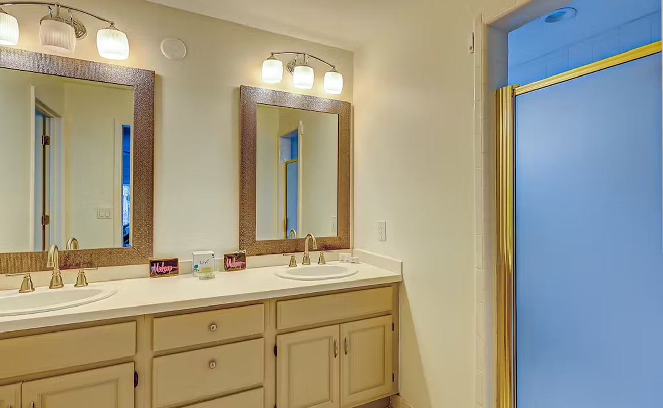 Your spacious bathroom features dual vanities with elegant lighting, providing ample space to prepare for your day in comfort.