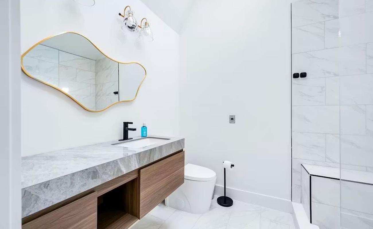 Indulge in your private spa-like bathroom with marble counters, modern fixtures, and a luxurious glass-enclosed shower.