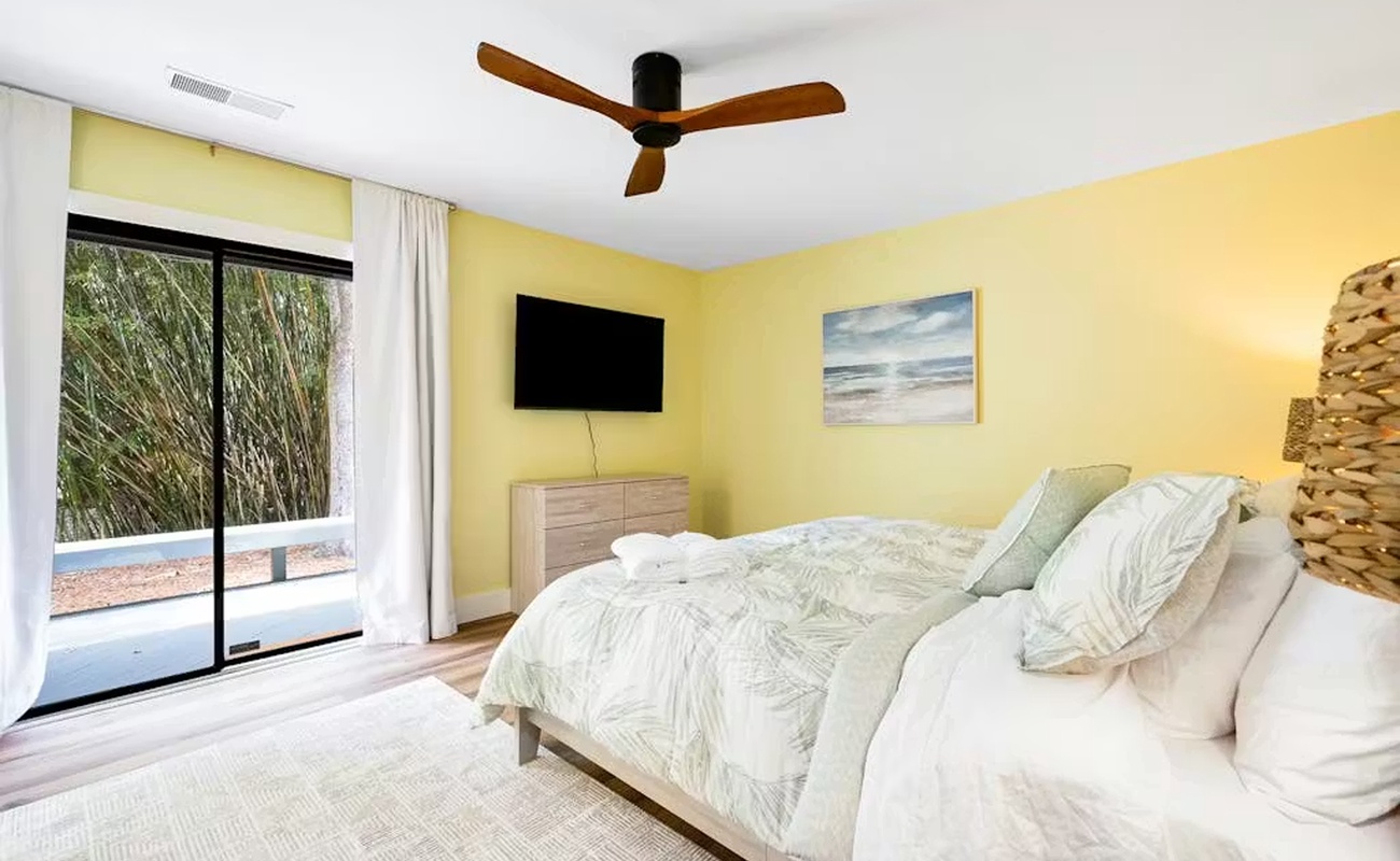 Drift off in this sunny bedroom with crisp linens, tropical views, and a soothing coastal breeze from your ceiling fan.