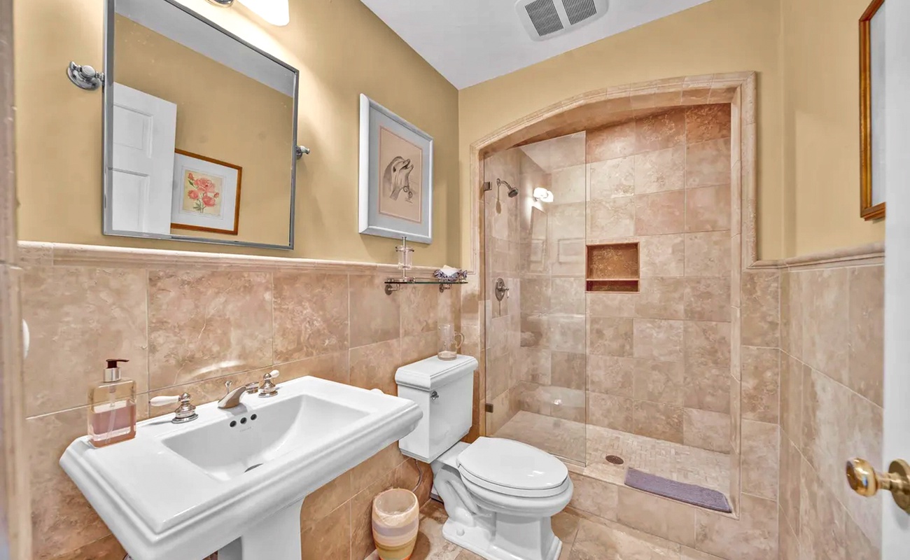 Unwind in your elegant travertine bathroom featuring a spacious walk-in shower and classic design touches that create a spa-like retreat.