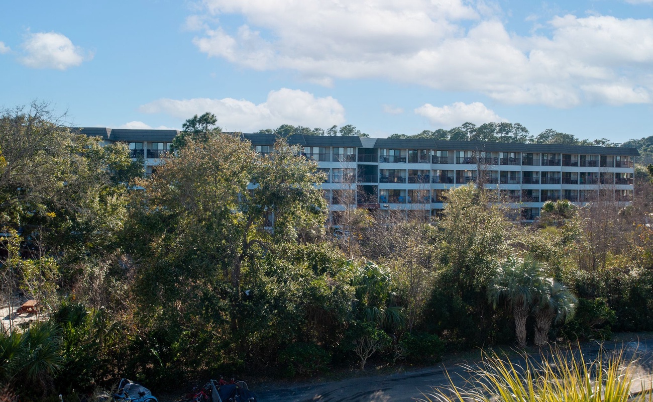 Modern apartment complex nestled among lush greenery offers a peaceful retreat with natural surroundings and contemporary architecture.