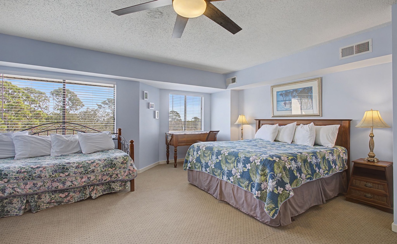 Wake up in this spacious bedroom where tropical bedding and gentle ceiling fan breezes create your perfect getaway retreat.