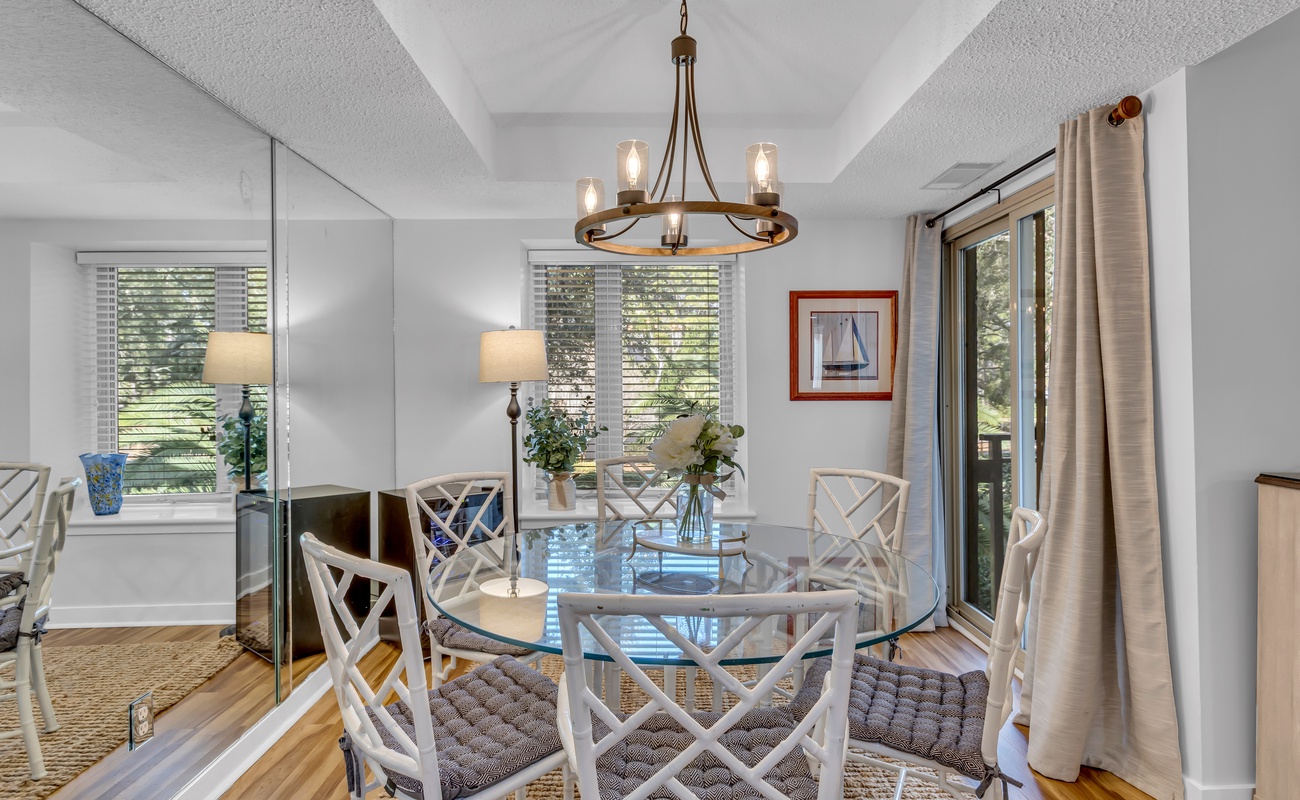 Gather around this elegant glass dining table where morning coffee and evening conversations flow naturally in your bright, airy space.
