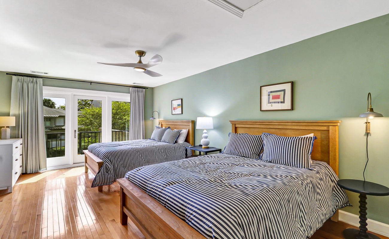 Unwind in your tranquil bedroom with twin beds, where soft green walls and striped bedding create a peaceful retreat after exploring.