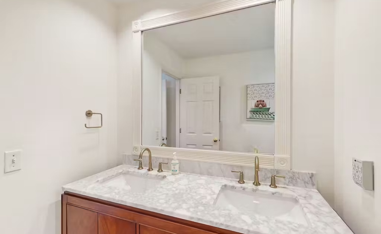 Refresh in your elegant dual-sink vanity with gleaming marble countertops and polished fixtures—perfect for your morning routine.