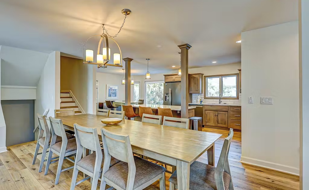 Gather around the spacious dining table where your group can share meals and make memories in this open-concept living space.