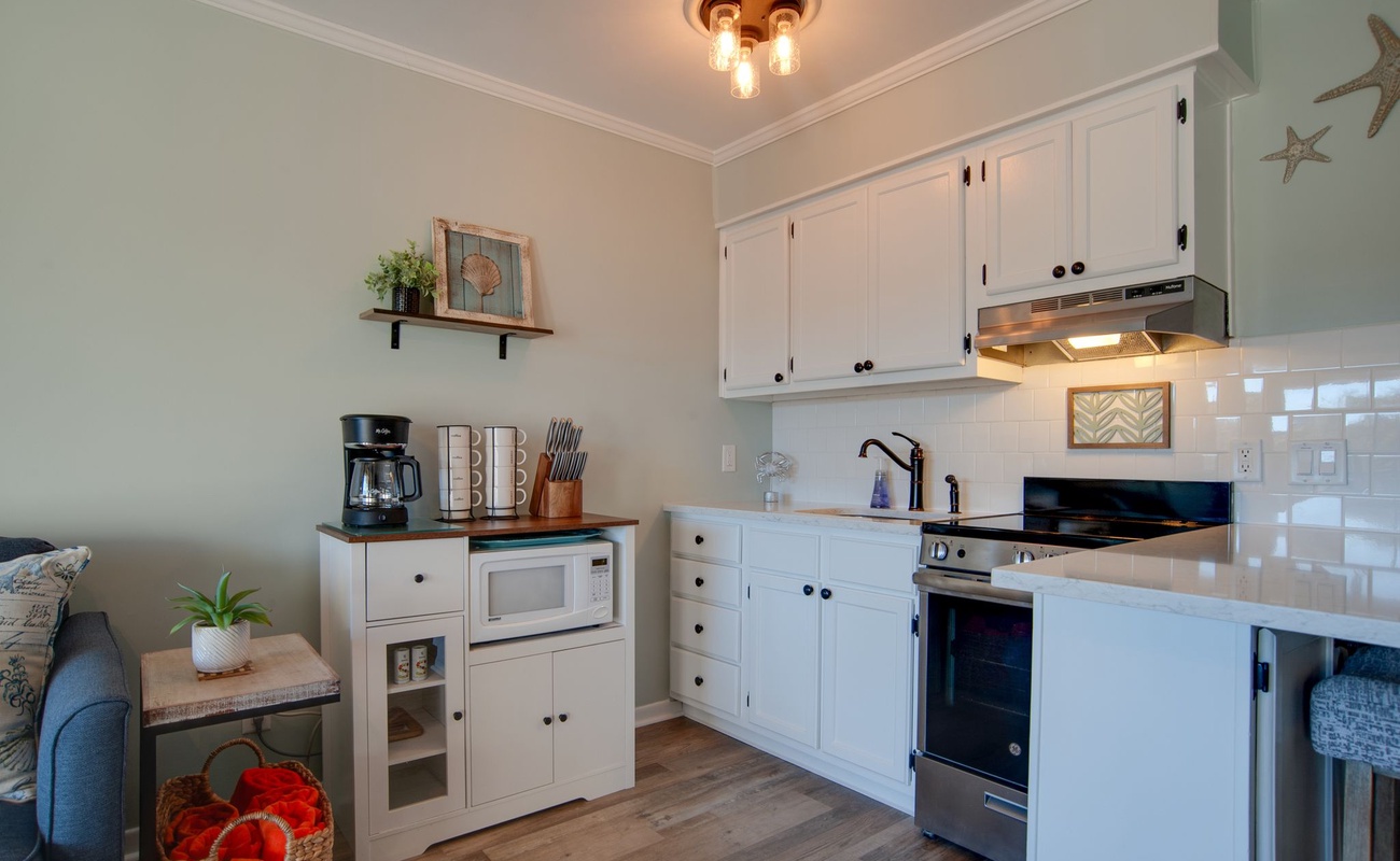 Your coastal-inspired kitchen awaits with white cabinetry, warm wood counters, and everything you need to create memorable meals during your stay.