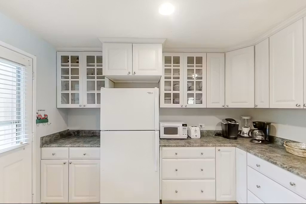 Your fully equipped kitchen awaits with granite counters, white cabinetry, and modern appliances for memorable meal preparation during your stay.