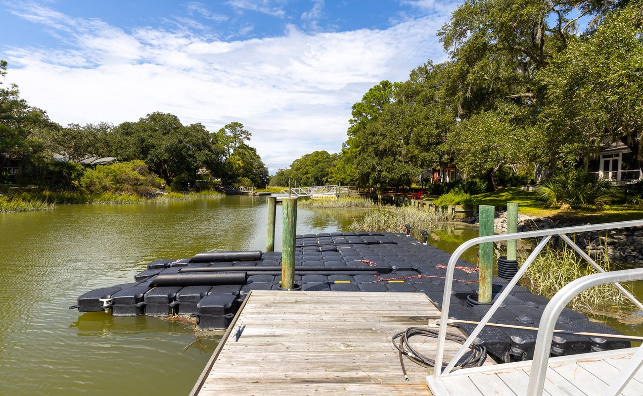 Private waterfront setting with scenic canal views and mature oak trees creating a peaceful residential backdrop.