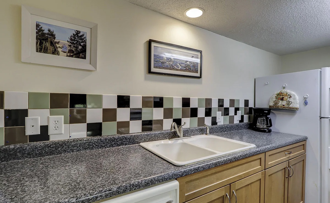 Your fully equipped kitchen features granite counters, colorful tile backsplash, and modern appliances for all your cooking needs.