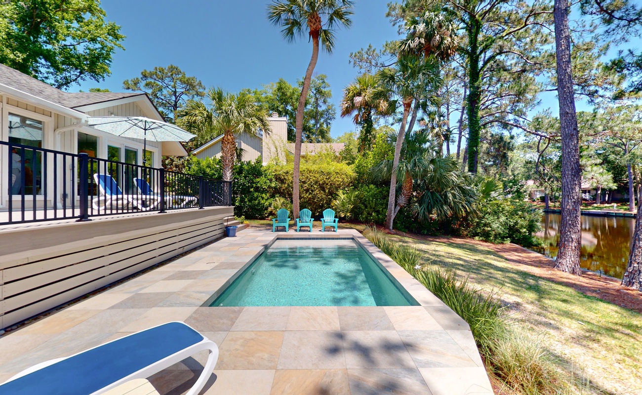 Dive into your private oasis surrounded by towering palms and lush tropical landscaping, perfect for poolside relaxation.