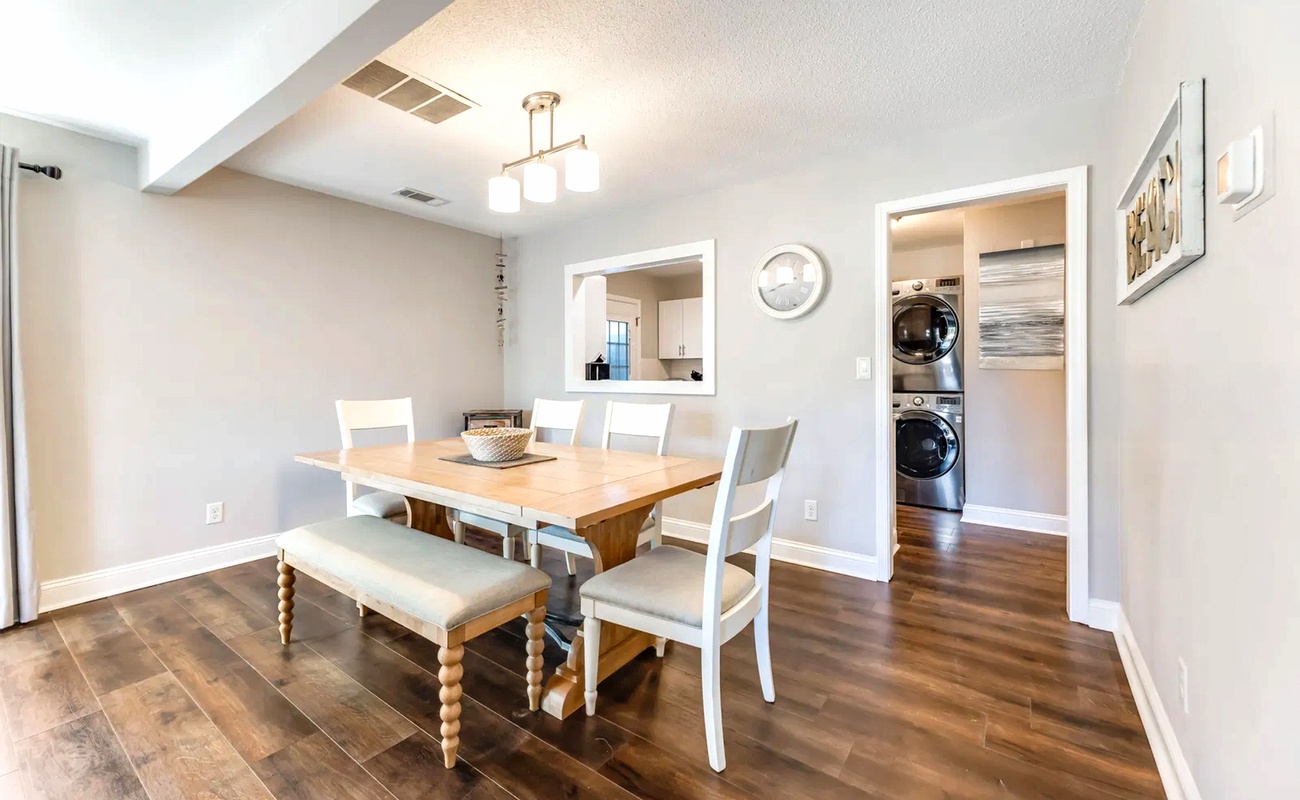 Gather around the warm wood dining table where memories are made, with convenient laundry facilities just steps away.