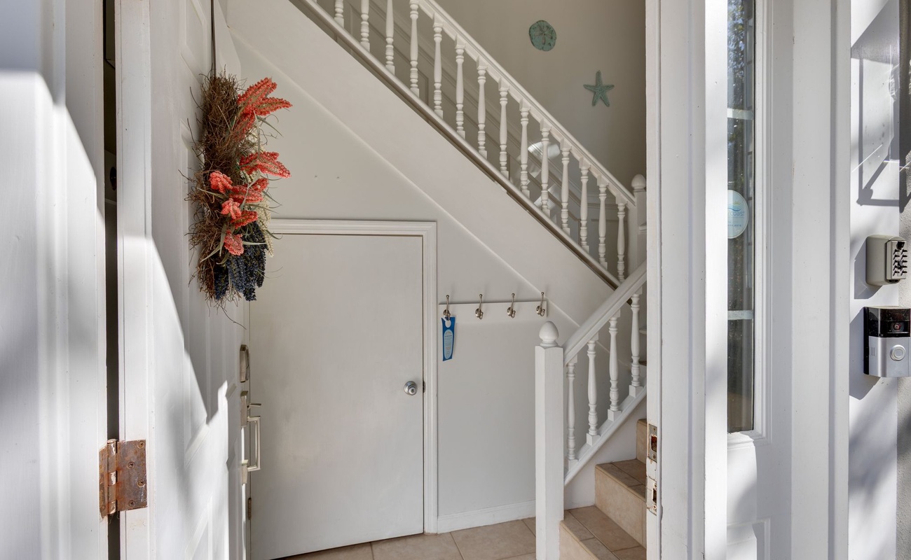 Step into your coastal retreat's bright entryway, where charming nautical touches and natural light create an instantly welcoming atmosphere.