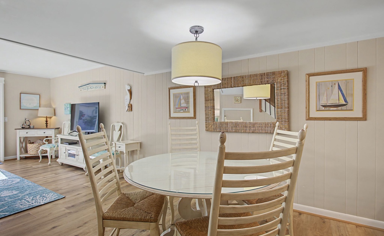 Relax in your coastal-inspired dining space with nautical artwork and warm wood accents creating the perfect atmosphere for memorable meals.