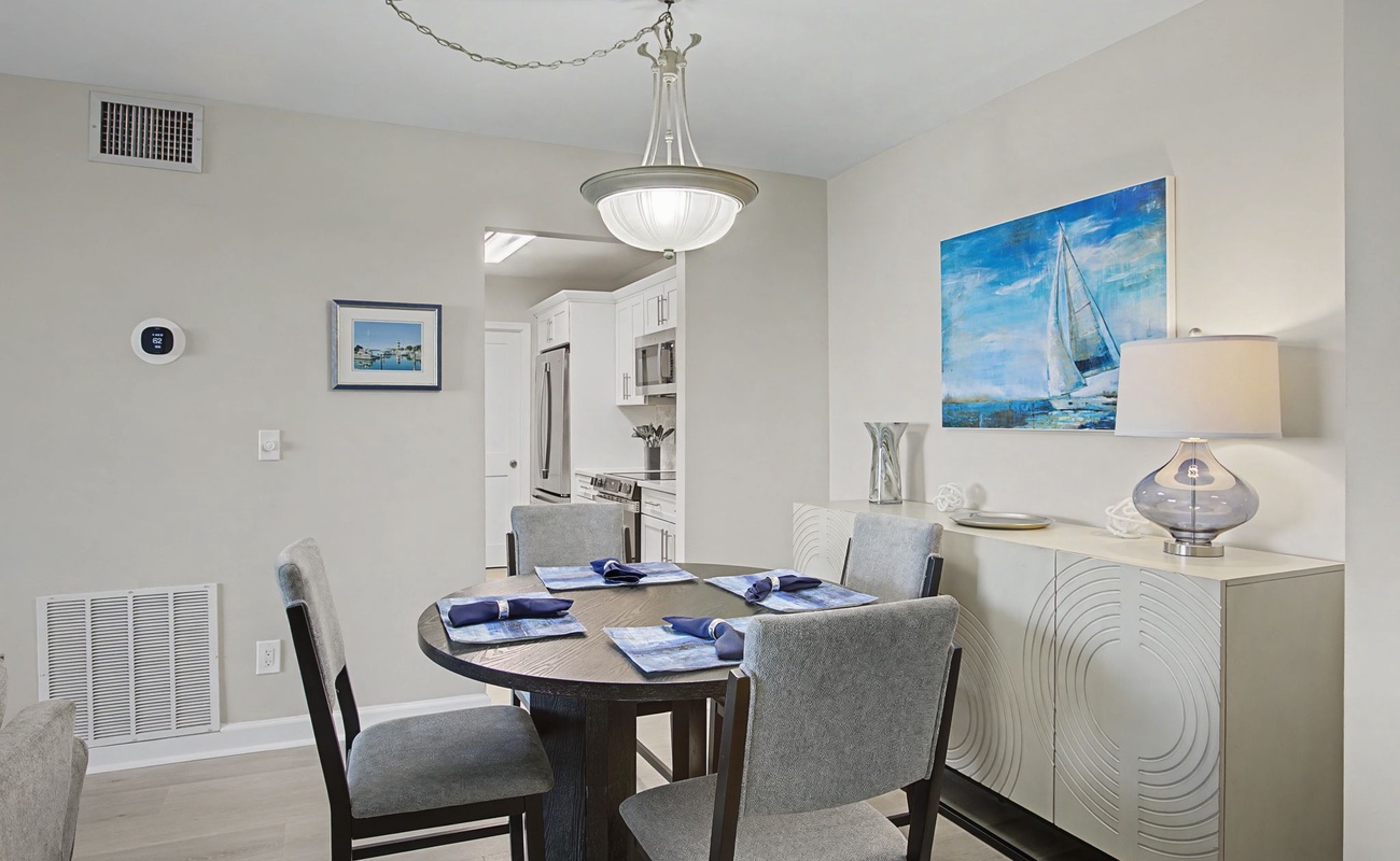 Gather around your elegant dining table where nautical artwork and stylish furnishings create the perfect setting for memorable meals together.